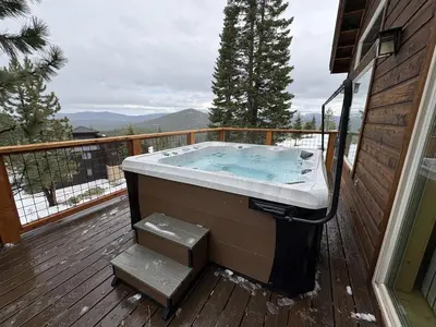 a hot tub on the deck of a house at Tahoe Donner Pinnacle Loop Mountain Retreat home in Truckee