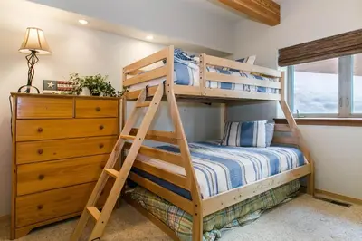 a bunk bed with a ladder in a bedroom at Northstar Conifer Luxury Home home in Truckee