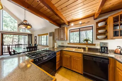 a kitchen with wooden cabinets and black appliances at The Arrow House in Camp Connell