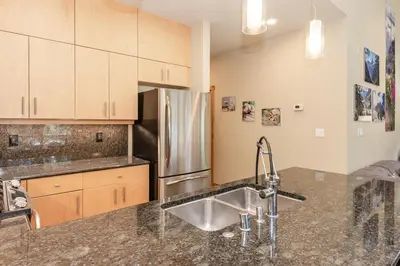 a kitchen with a sink and a stainless steel refrigerator at Solstice 24 in Mammoth Lakes