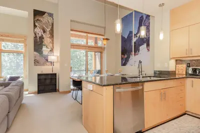 a kitchen with a sink and a living room at Solstice 24 in Mammoth Lakes