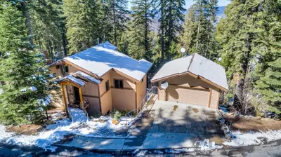 a house in the woods with snow on it at Canyons Crest in Yosemite West