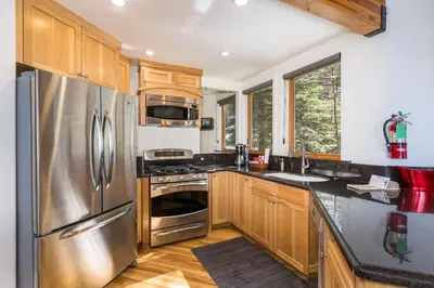 a kitchen with stainless steel appliances and wooden cabinets at Canyons Crest in Yosemite West