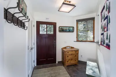 a hallway with a brown door and a wooden dresser at Canyons Crest in Yosemite West