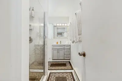 a white bathroom with a shower and a door at Piney Retreat in Carnelian Bay