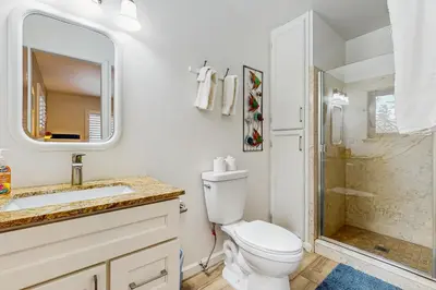 a white bathroom with a toilet and a shower at Piney Retreat in Carnelian Bay