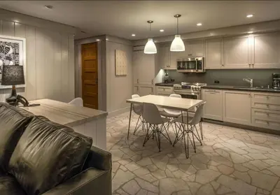 a kitchen with a table and chairs and a table and a couch at Cedar Crest - Chickadee Cottage 2 in Homewood