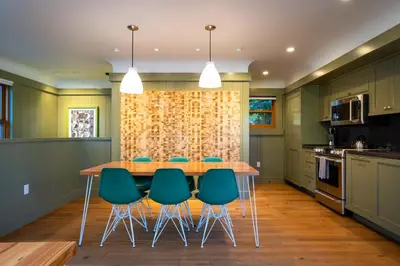 a kitchen with a wooden table and green chairs at Cedar Crest - Mallard Cottage 5 in Homewood