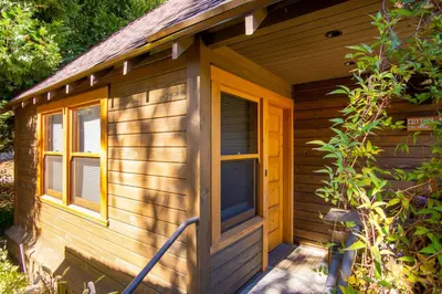 a wooden cabin with a porch and a window at Cedar Crest - Mallard Cottage 5 in Homewood
