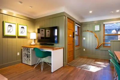 a room with a desk with a television and a chair at Cedar Crest - Mallard Cottage 5 in Homewood