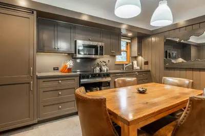 a kitchen with a wooden table and chairs at Cedar Crest - Osprey Cottage 3 in Homewood