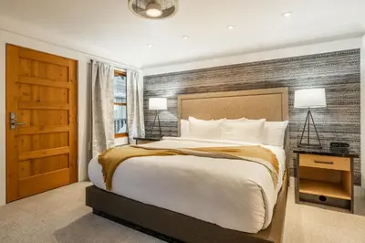 a bedroom with a large bed and a wooden wall at Cedar Crest - Osprey Cottage 3 in Homewood