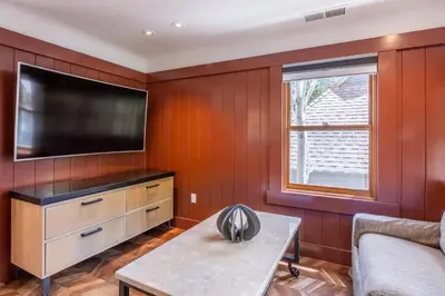 a living room with wood paneling and a flat screen tv at Cedar Crest - Robin Cottage 6 in Homewood