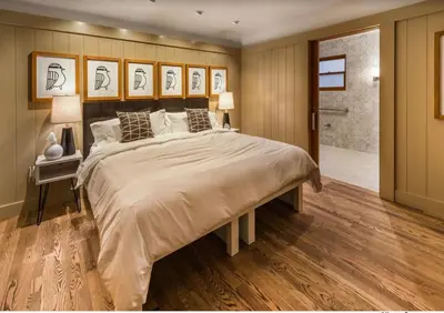 a bedroom with a large bed and a walk in shower at Cedar Crest - Sparrow Cottage 1 in Homewood