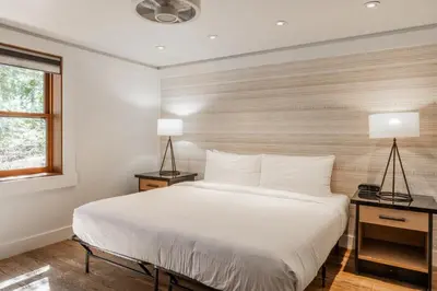 a bedroom with a white bed and two lamps at Cedar Crest - Sparrow Cottage 1 in Homewood