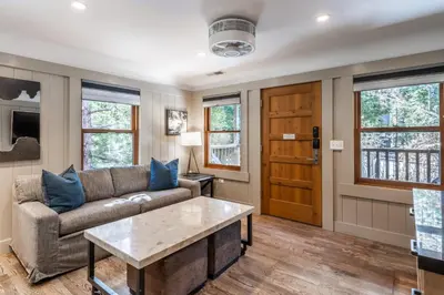 a living room with a couch and a table at Cedar Crest - Sparrow Cottage 1 in Homewood