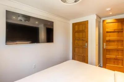 a bedroom with a bed and a flat screen tv at Cedar Crest - Woodpecker Cottage 7 in Homewood