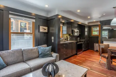 a living room with a couch and a kitchen at Cedar Crest - Woodpecker Cottage 7 in Homewood