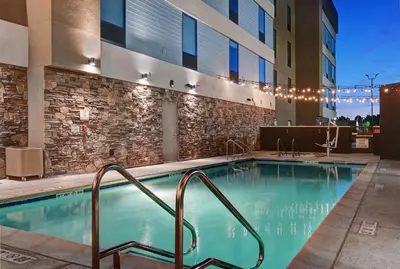 a swimming pool at a hotel with a building at Home2 Suites By Hilton Tracy, Ca in Tracy