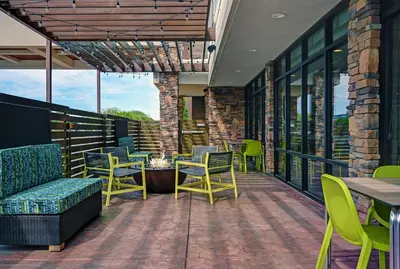 a patio with chairs and tables on a balcony at Home2 Suites By Hilton Tracy, Ca in Tracy