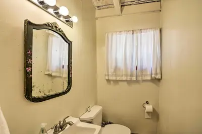 a bathroom with a sink and a toilet and a mirror at Secluded Camp Connell Home with Deck and Fireplace! in Camp Connell