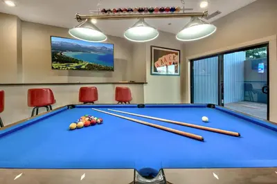 a pool table in a room with red chairs at LUXE 15 Blue Diamond Lodge Lake Tahoe Hot Tub in Stateline