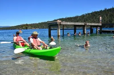 a group of people in a green kayak in the water at LUXE 4 Blue Diamond Lake Tahoe Lodge in Stateline