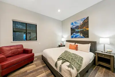 a bedroom with a bed and a red chair at LUXE 11 Blue Diamond Lodge Lake Tahoe in Stateline