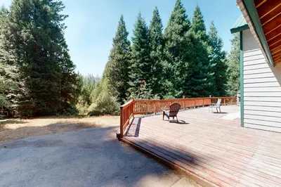 a wooden deck with two benches on a house at Papas Mountain in Shaver Lake