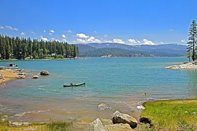 a person in a boat in a large body of water at Papas Mountain in Shaver Lake