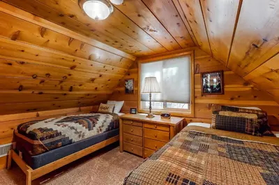 a bedroom with two beds in a log cabin at Williams Cabin in Shaver Lake