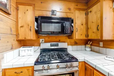 a kitchen with a stove and a microwave at Williams Cabin in Shaver Lake