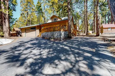 a house in the woods with a driveway at Williams Cabin in Shaver Lake