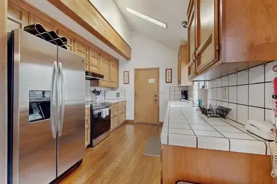 a kitchen with a stainless steel refrigerator and wooden cabinets at Whispering Pines in Shaver Lake