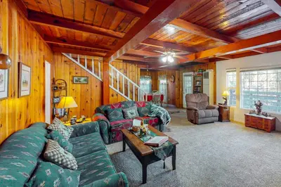 a living room with couches and a table in a house at Maul Cabin in Shaver Lake