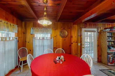 a dining room with a red table and white chairs at Maul Cabin in Shaver Lake