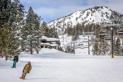 two people are standing in the snow on a ski slope at Forest Creek 26 in Mammoth Lakes
