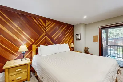 a bedroom with a large bed with a wooden headboard at Private Beach Retreat in Zephyr Cove
