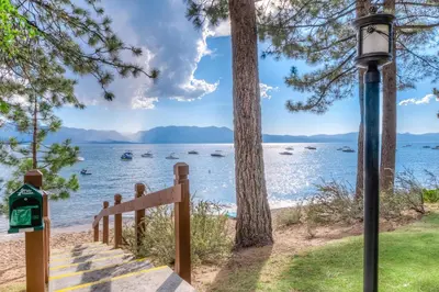 a staircase leading to the beach with boats in the water at Private Beach Retreat in Zephyr Cove