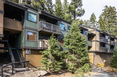 a green apartment building with trees in front of it at Bigwood 32 in Mammoth Lakes