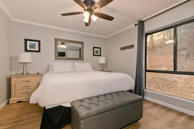 a bedroom with a bed with a ceiling fan and a window at Bigwood 32 in Mammoth Lakes
