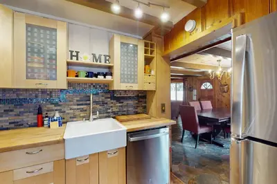 a kitchen with a sink and a refrigerator and a table at Tahoe Delight in Tahoe City
