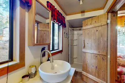 a bathroom with wooden walls and a sink and a shower at Tahoe Delight in Tahoe City