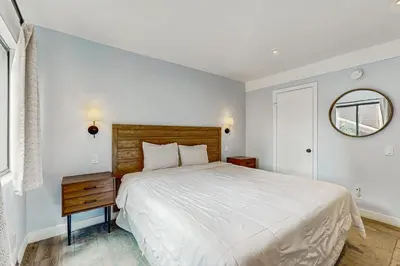 a bedroom with a large white bed and a mirror at Mammoth Ski & Racquet 93K in Mammoth Lakes