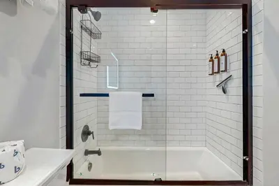a bathroom with a bath tub with a glass shower door at Mammoth Ski & Racquet 93K in Mammoth Lakes