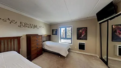a bedroom with a bed and a dresser and a window at Spacious 3 Bed 3 Bath Condo with Pool in Mammoth Lakes