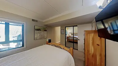 a bedroom with a white bed and a window at Spacious 3 Bed 3 Bath Condo with Pool in Mammoth Lakes
