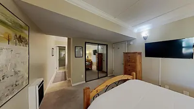 a bedroom with a bed and a tv on the wall at Spacious 3 Bed 3 Bath Condo with Pool in Mammoth Lakes