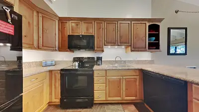 a kitchen with wooden cabinets and a black dishwasher at Spacious 4 Bed 3 Bath Condo Great For Families! in Mammoth Lakes
