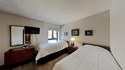 a bedroom with two beds and a flat screen tv at Fantastic 3 Bedroom Condo with Great Views in Mammoth Lakes